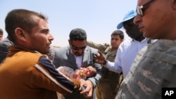 Các giới chức Liên Hiệp Quốc đi thăm những người bị thất tán đến từ các khu vực xung quanh Ramadi, Iraq.