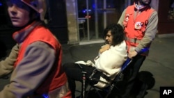 A woman being evacuated from the Bataclan theater after a shooting in Paris, Nov. 13, 2015.