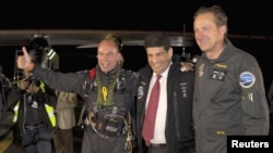 The Solar Impulse plane's project president and pilot, Bertrand Piccard (L) celebrates with co-founder and CEO Andre Borschberg (R) and Moroccan Agency for Solar Energy (MASEN) CEO Mustapha Bakkoury after the plane landed following a 19-hour flight from M