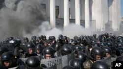 Smoke rises outside Ukraine's parliament building as riot police clash with nationalist protesters, in Kyiv, Aug. 31, 2015.