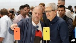 Jonathan Ive, Apple's chief design officer, left, looks at some new iPhone models with CEO Tim Cook during an event to announce new products Wednesday, Sept. 12, 2018, in Cupertino, Calif. (AP Photo/Marcio Jose Sanchez)