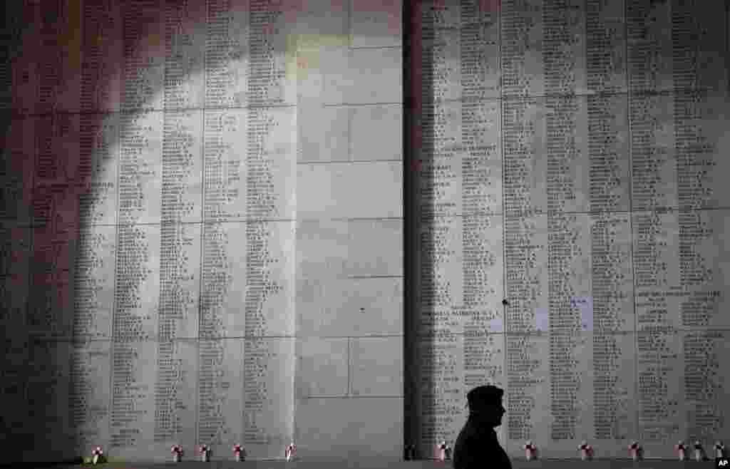 A soldier walks by wooden crosses and names of the missing during an Armistice ceremony at the Menin Gate in Ypres, Belgium.