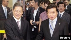 Zhang Zhijun (L), director of China's Taiwan Affairs Office, shakes hands with Mainland Affairs Council Vice Minister Chang Hsien-yao, after arriving at Taoyuan International Airport, northern Taiwan, June 25, 2014.