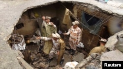 Indo-Tibetan Border Police personnel search for flood victims in a damaged house in Uttarkashi in the Himalayan state of Uttarakhand, June 26, 2013.