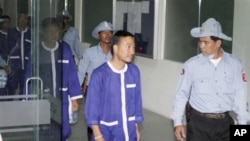 Panich Vikitsreth, center, a member of Thailand's Parliament , is escorted by Cambodian court security personnel upon his workout at Phnom Penh Municipal Court on Thursday. 