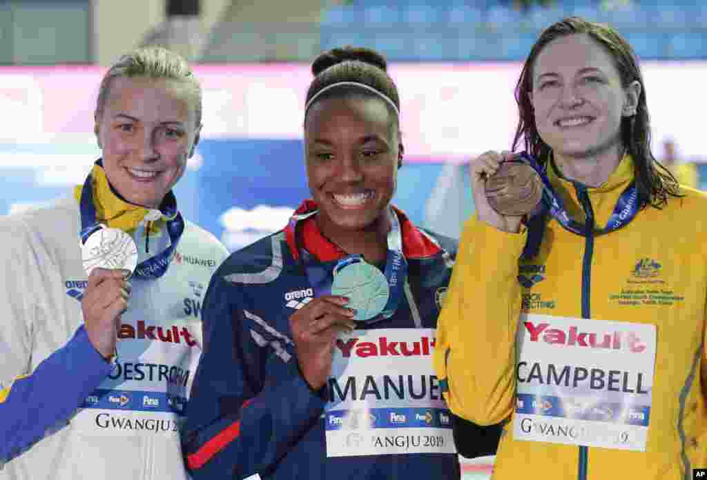 سیمونه منوئل دختر ۲۲ ساله آمریکایی (وسط) قهرمانی خود را در مسابقات شنای قهرمانی جهان در کره جنوبی جشن می&zwnj;گیرد. در رشته پنجاه متر آزاد، بعد از این ورزشکار آمریکایی، ورزشکاران سوئد (چپ) و استرالیا دوم و سوم شدند.