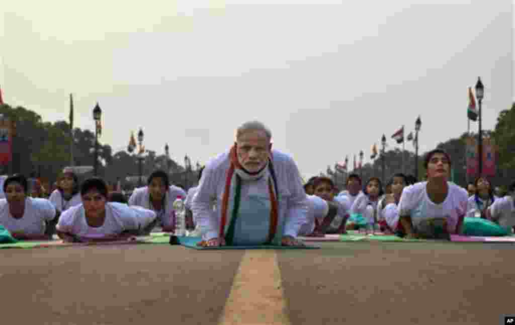 Indian Prime Minister Narendra Modi lies down on a mat as he performs yoga along with thousands of Indians on Rajpath, in New Delhi, India, Sunday, June 21, 2015. Millions of yoga enthusiasts are bending their bodies in complex postures across India as th