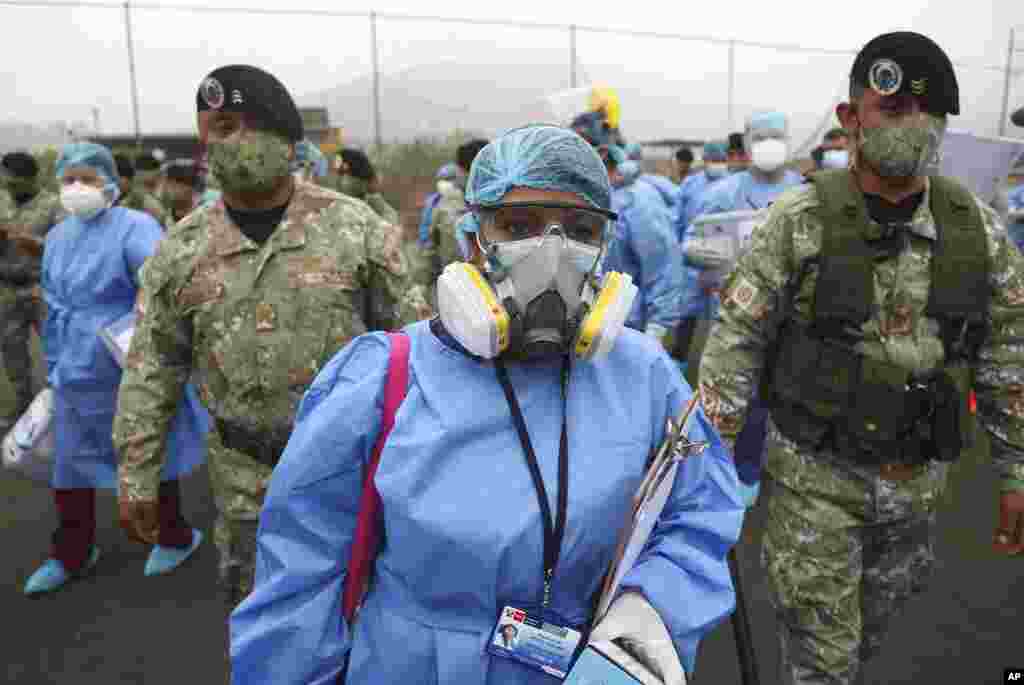 Health workers are escorted by soldiers during a house-to-house COVID-19 testing campaign in the Villa Maria del Triunfo shantytown of Lima, Peru.