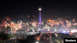 Pesta kembang api menerangi Monumen Nasional pada perayaan Tahun Baru di Jakarta, 1 Januari 2018. (Antara Foto/Wahyu Putro/ via REUTERS)