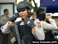 FILE - Anggota polisi khusus mempersiapkan patroli keamanan di sekitar kawasan turis di Kuta, dekat Denpasar, Bali, 23 Maret 2017. (Sonny Tumbelaka/AP)