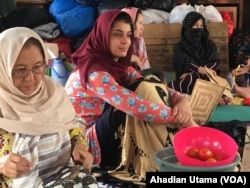 Para wanita pengungsi asal Afghanistan beristirahat di tenda darurat.