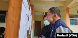 Warga melihat daftar nama 10 korban meninggal kegiatan susur sungai di SMPN 1 Turi, Sleman, Yogyakarta, 23 Februari 2020. Kejadian nahas itu terulang pada 11 siswa MTs Ciamis yang tewas karena susur sungai pada 15 Oktober 2021. (Foto:VOA/ Nurhadi)