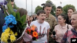 Ukrainian pilot Nadezhda Savchenko, center, speaks to the media upon her arrival at Boryspil airport outside Kiev, Ukraine, May 25, 2016.
