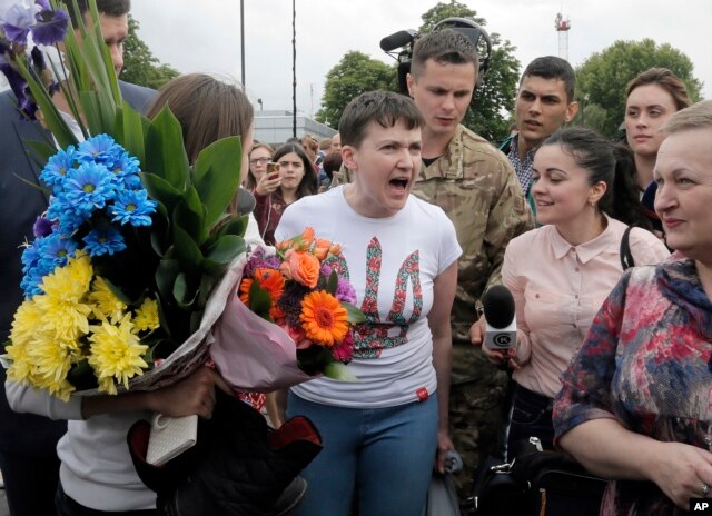 FILE - Ukrainian pilot Nadiya Savchenko, center, speaks to the media upon her arrival at Boryspil airport outside Kyiv, Ukraine, following her arrival from Russia in a prisoner swap, May 25, 2016.