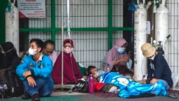 Sejumlah warga antre untuk memasuki ruang gawat darurat rumah sakit yang merawat pasien COVID-19 di Surabaya pada 11 Juli 2021. Pakar mengatakan gelombang ketiga di Indonesia adalah keniscahayaan. (Foto: AFP)