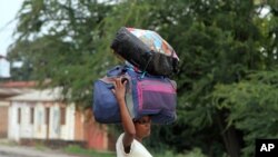Photo uniquement à titre d’illustration : Une femme transporte ses effets personnels à Bujumbura, le 7 novembre 2015. (AP Photo)