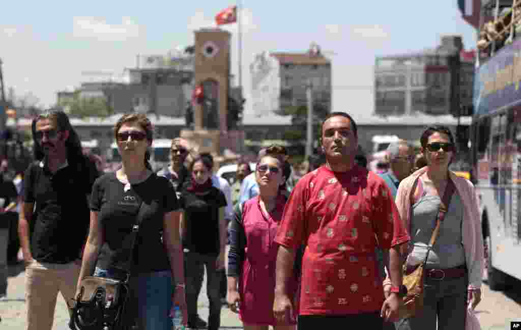 People stand in a silent protest in Taksim Square, Istanbul, June 18, 2013.