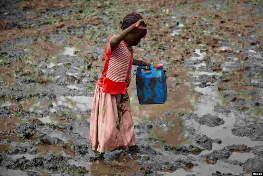A girl walks through mud to get water at the Yusuf Batil refugee camp in Upper Nile, South Sudan, July 4, 2012.
