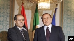 Italian premier Silvio Berlusconi, right, shakes hand with Mahmoud Jibril, deputy chairman of the Libyan National Transitional Council, at the prefecture building in Milan, Italy, August 25, 2011