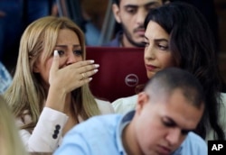 Marwa Fahmy, wife of Canadian Al-Jazeera English journalist Mohammed Fahmy, left, sitting with human rights lawyer Amal Clooney, bursts into tears as the verdict is read in a courtroom in Tora prison in Cairo, Egypt, Aug. 29, 2015.