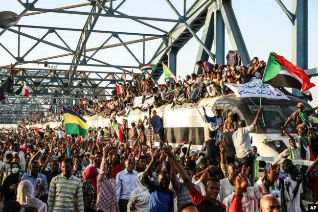 Sudanese protesters crowd a train in the capital Khartoum, April 23, 2019, demanding the military hand over power to a civilian body.