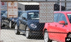 Volkswagen diesels are shown behind a security fence on a storage lot near a VW dealership Sept. 23, 2015, in Salt Lake City.