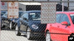 FILE - Volkswagen diesels are shown behind a security fence on a storage lot near a VW dealership Sept. 23, 2015, in Salt Lake City, Utah.