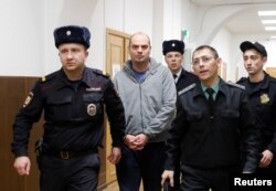 Former Chairman of Vostochny Bank board Alexei Kordichev, who was detained on suspicion of embezzlement, is escorted inside a court building in Moscow, Russia, Feb. 15, 2019.