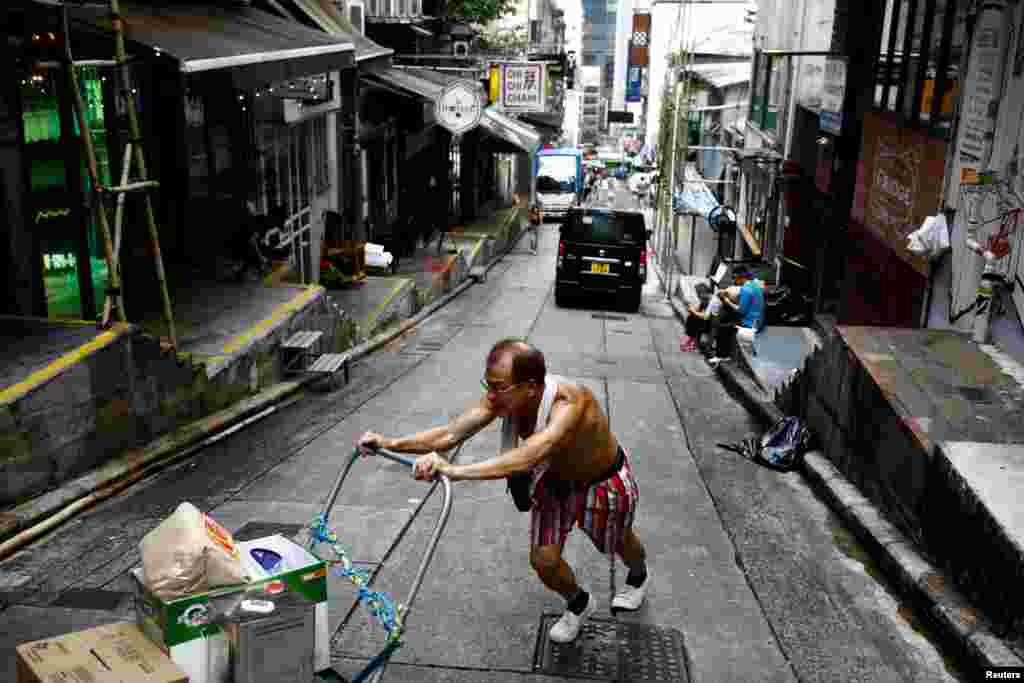홍콩 성완의 거리에서 남성이 카트를 밀고 있다.