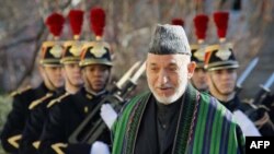 Afghan President Hamid Karzai reviews the honor guard during his arrival at the French National Assembly in Paris, Friday, Jan. 27, 2012. (AP Photo/Michel Spingler)