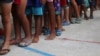 ARCHIVO - Niños migrantes venezolanos hacen fila dentro de un coliseo donde se ha instalado un campamento temporal, luego de huir de su país, según la agencia colombiana de migración, en Arauquita, Colombia, 26 de marzo de 2021.