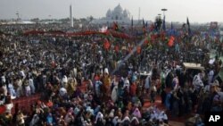 Thousands of supporters of Pakistan's former prime minister Benazir Bhutto take part in a rally to mark the fourth anniversary of her assassination at her tomb, seen in background, in Gari Khuda Bux near Larkana, Pakistan, December 27, 2011.