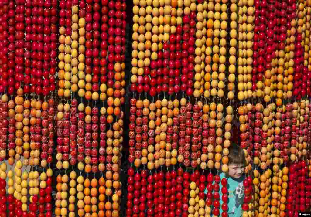 A boy plays with an installation made of painted wooden eggs, attributes of the Orthodox Easter, in central Kiev, Ukraine. Orthodox believers will celebrate Easter on May 5.