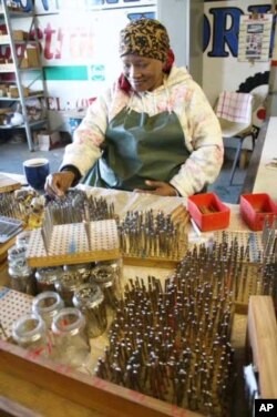 AMI worker Lena van Heerden sorts through high quality spring steel (in foreground) for use in the firm’s kalimbas