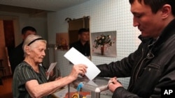 An elderly Kazakh woman votes at her home in Kazakhstan's commercial capital Almaty, January 15, 2012.