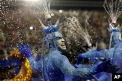FILE - Performers from the Portela samba school sport waterspouts on their heads during Carnival celebrations at the Sambadrome in Rio de Janeiro, Brazil, Feb. 9, 2016.