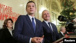 Sorin Grindeanu (C) gestures while answering a question during a press conference held alongside Romania's Social Democrat Party (PSD) leader, Liviu Dragnea (R), in Bucharest, Romania Dec. 28, 2016.