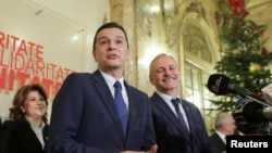 Sorin Grindeanu (C) gestures while answering a question during a press conference held alongside Romania's Social Democrat Party (PSD) leader, Liviu Dragnea (R), in Bucharest, Romania Dec. 28, 2016.