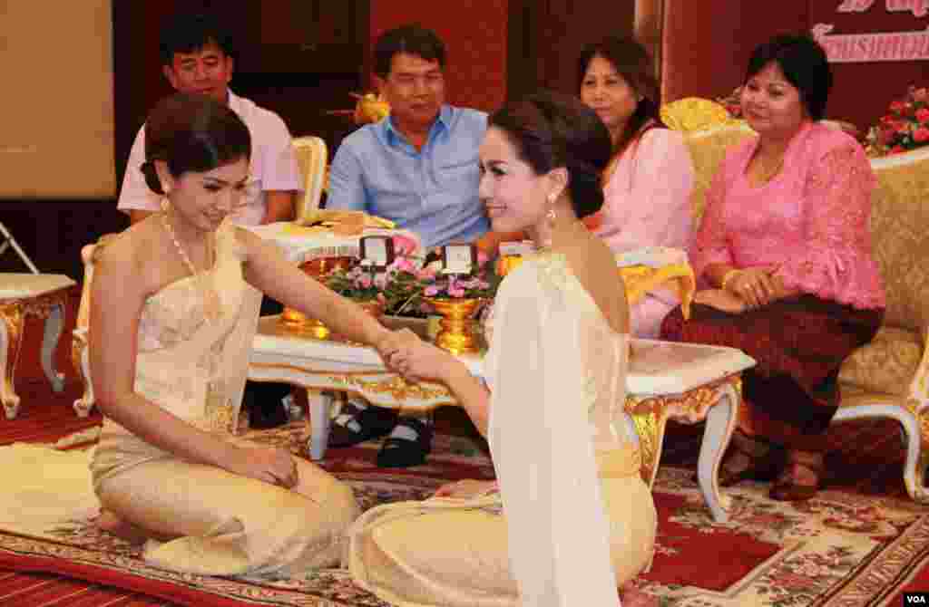 Orangtua kedua belah pihak menyaksikan pasangan Arisa Thanommek dan Pacharee Hungsabut&nbsp;bertukar cincin dalam upacara pernikahan di Bangkok (19/5). (VOA/Daniel Schearf)