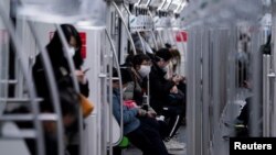 2020年2月10日早上，上海市民戴着口罩乘坐地铁去上班。