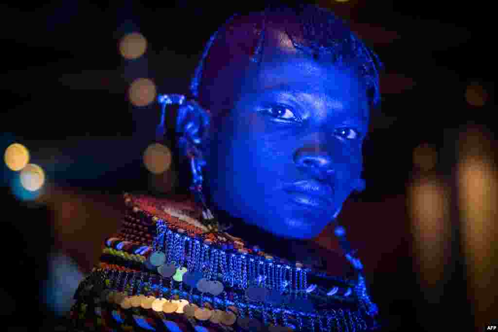 A dancer of Turkana tribe performs in blue light during the launching ceremony of the 11th Marsabit-Lake Turkana Cultural Festival in Nairobi, Kenya.