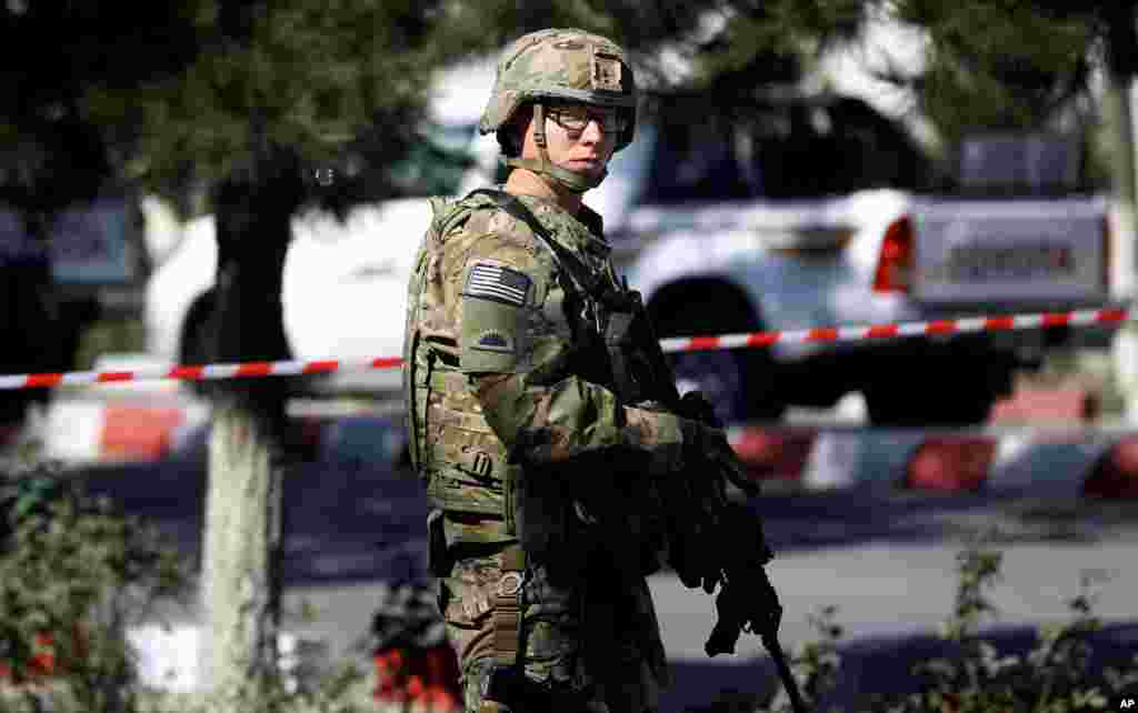 A U.S. military force stands guard at the site of a suicide attack near a U.S. military camp in Kabul, Sept. 16, 2014.