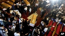 Coffins are taken into ambulances after a funeral service for victims of a Sunday cathedral bombing, at the Virgin Mary Church, in Cairo, Egypt, Dec. 12, 2016. 
