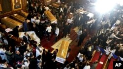 12일 이집트 카이로의 성마리아교회에서 전날 발생한 폭탄 테러 희생자들의 장례식이 거행된 후 관을 옮기고 있다.