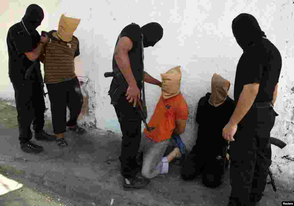 Hamas militants preparing to execute Palestinians suspected of collaborating with Israel, in Gaza City, Aug. 22, 2014.