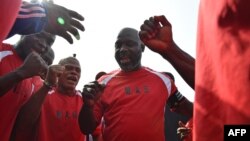 Le président-élu du Liberia George Weah joue amicalement avec des fans, le 20 janvier 2018.