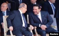 Saad al-Hariri talks with Lebanese President Michel Aoun while attending a military parade to celebrate the 74th anniversary of Lebanon's independence in downtown Beirut, Lebanon, Nov. 22, 2017.