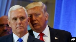 Tổng thống tân cử Donald Trump trao đổi với Phó Tổng thống tân cử Mike Pence trong một cuộc họp báo tại Tháp Trump. 