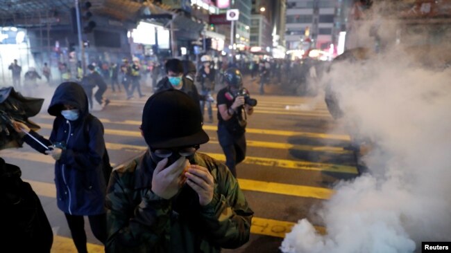 香港圣诞节平安夜举行的抗议活动中反政府示威者逃离警察发射的催泪弹。（2019年12月24日）