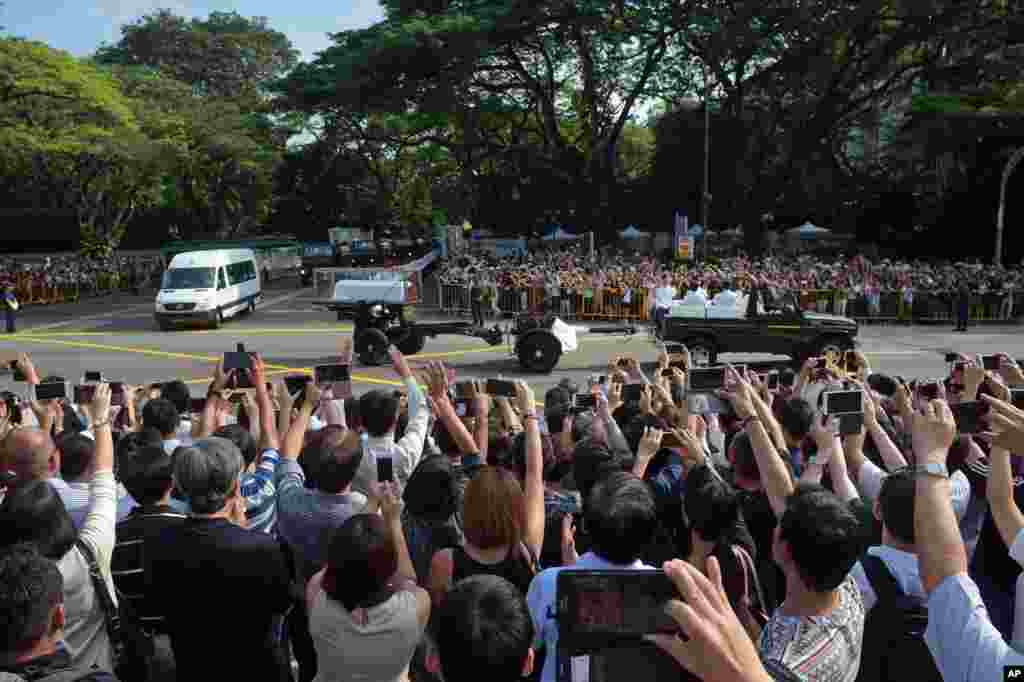 Members of the public take pictures and shout, &quot;Thank you, Mr Lee!&quot; as the coffin of Singapore&#39;s founding father Lee Kuan Yew leaves the Presidential Palace on a ceremonial gun carriage before lying in state at Parliament House, March 25, 2015.